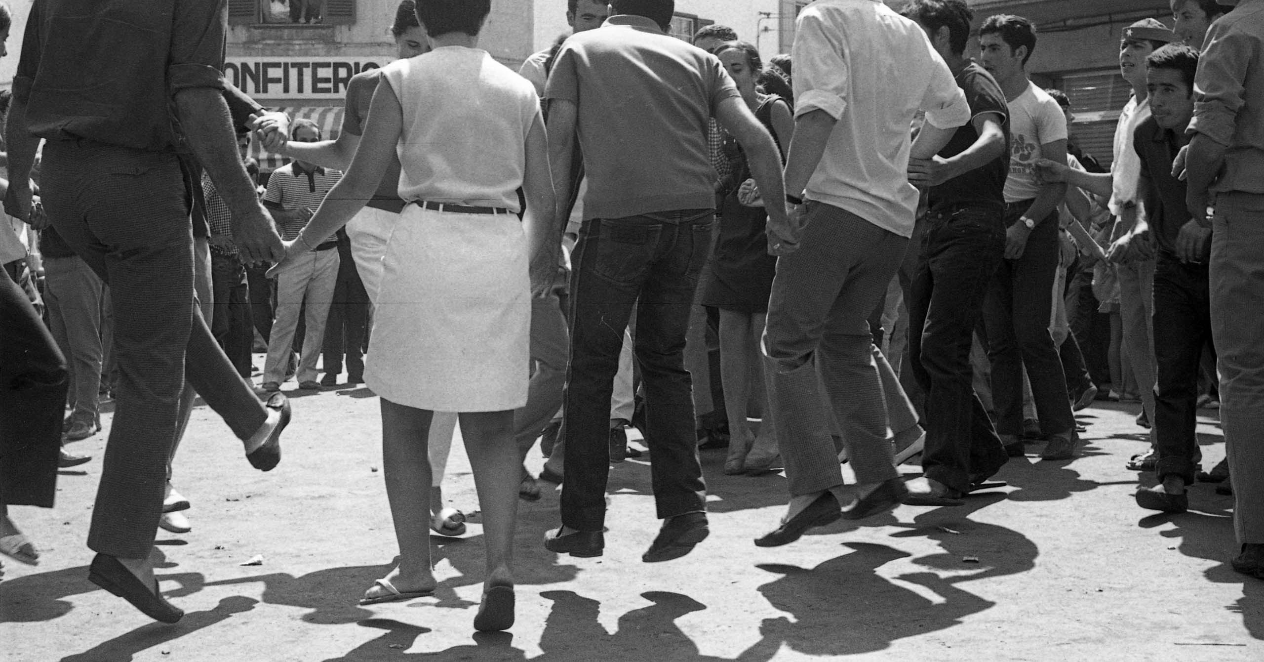 Los vecinos y vecinas de Es Mercadal bailando cerca de las pastelerias